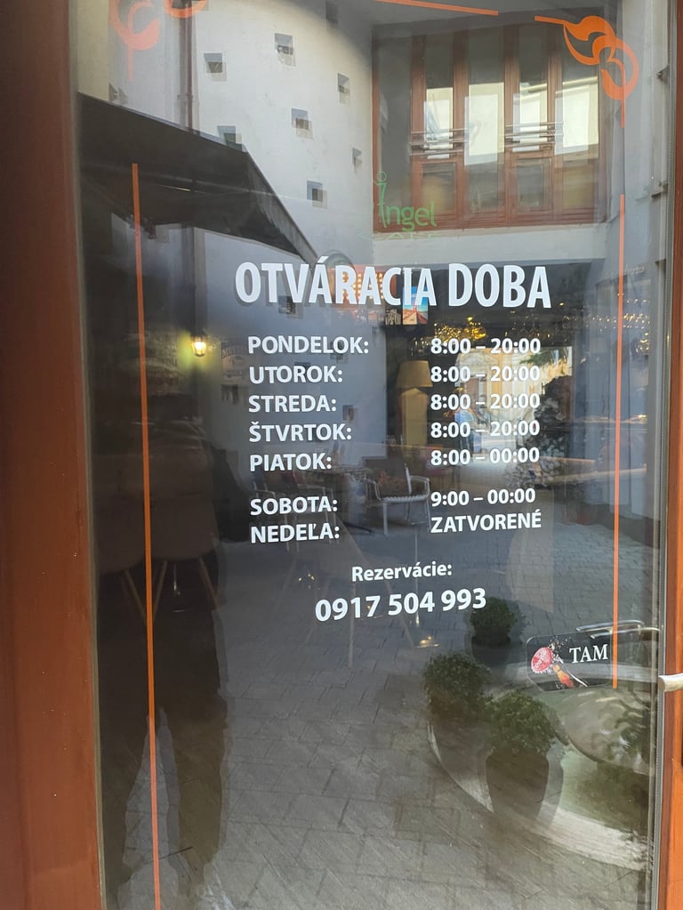 Glass door with business hours and contact information for Otvaracia Doba restaurant in Slovak language