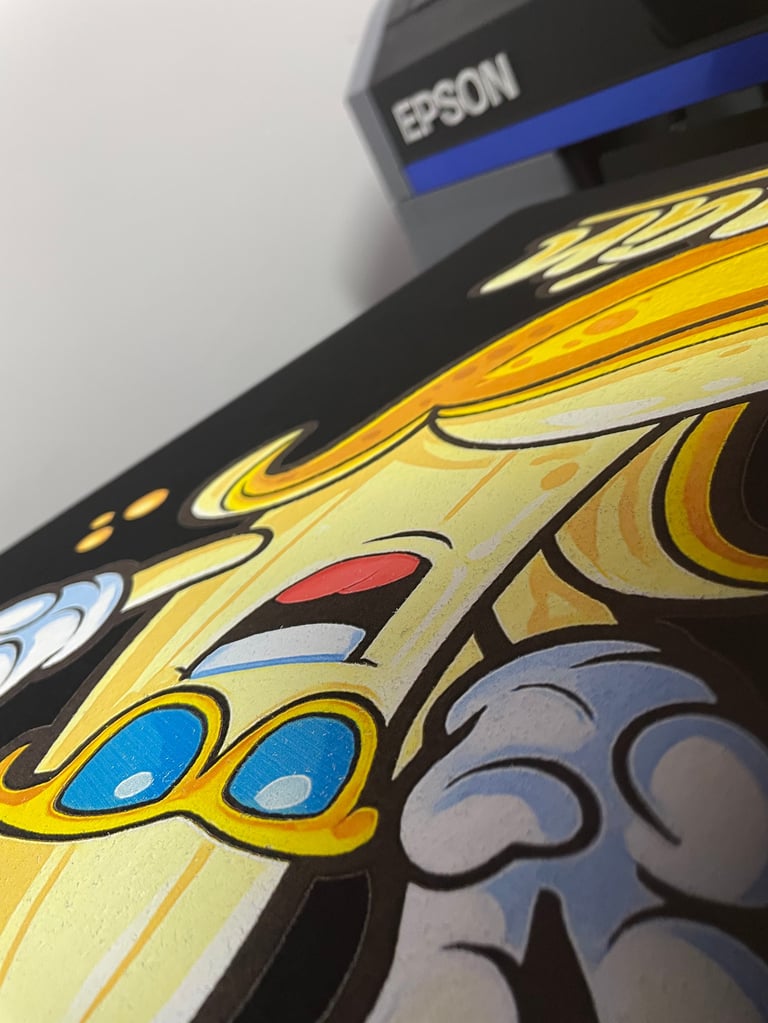 Close-up of an Epson printer with colorful cartoon artwork featuring a yellow character with blue eyes and decorative design printed on its surface